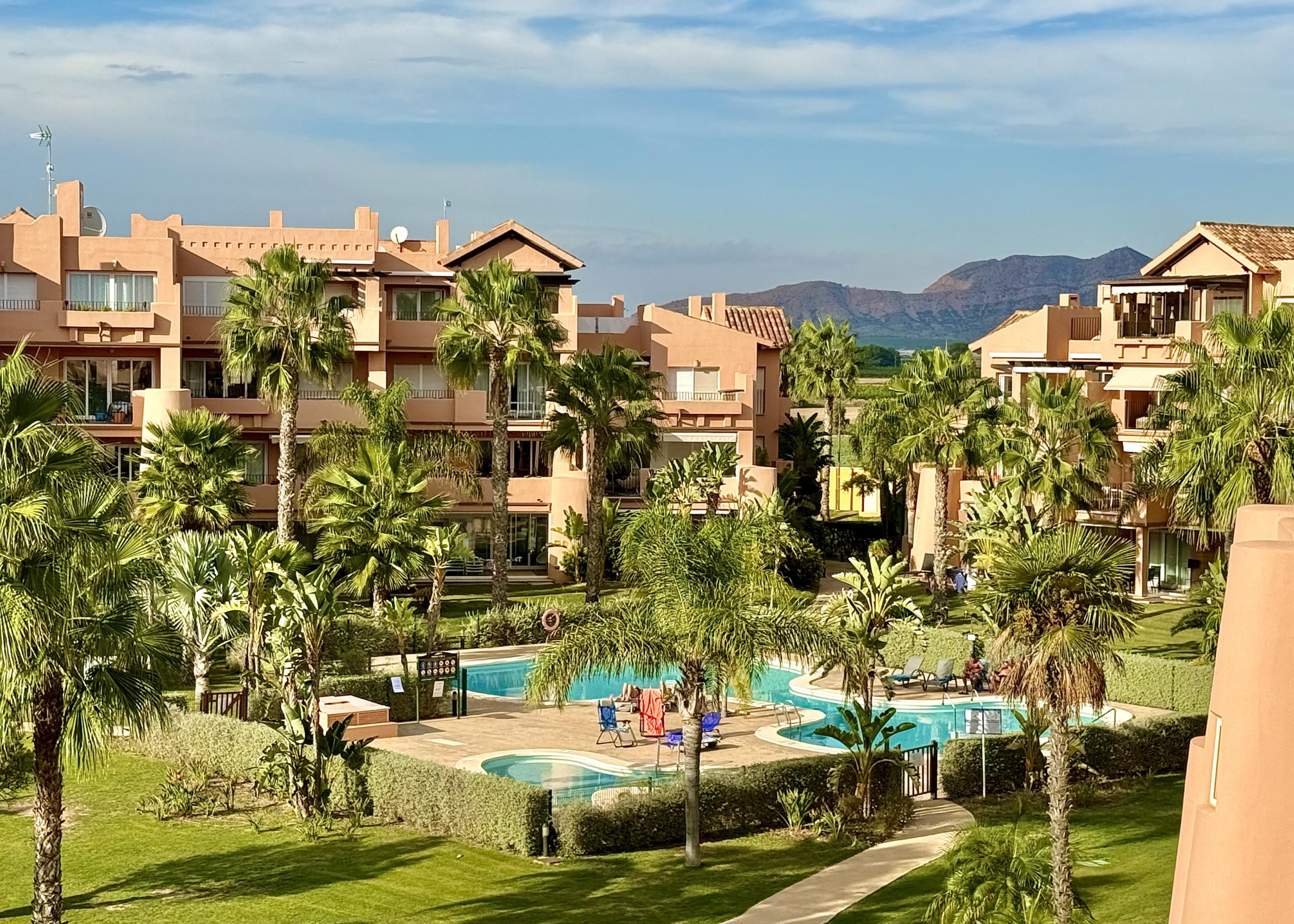 Outdoor swimming pool at Mar Menor Resort with sun loungers and palm trees