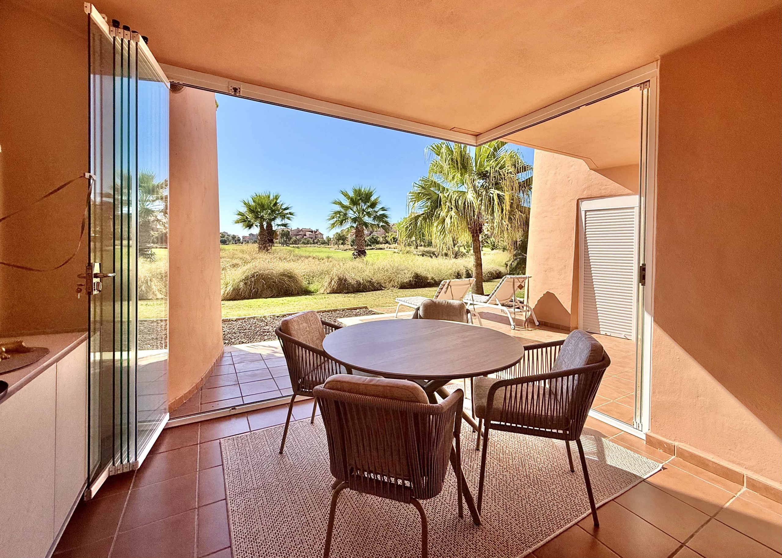Enclosed terrace with glass curtains overlooking the golf course and lake at Mar Menor Golf Resort, exclusively marketed by Levante Properties.