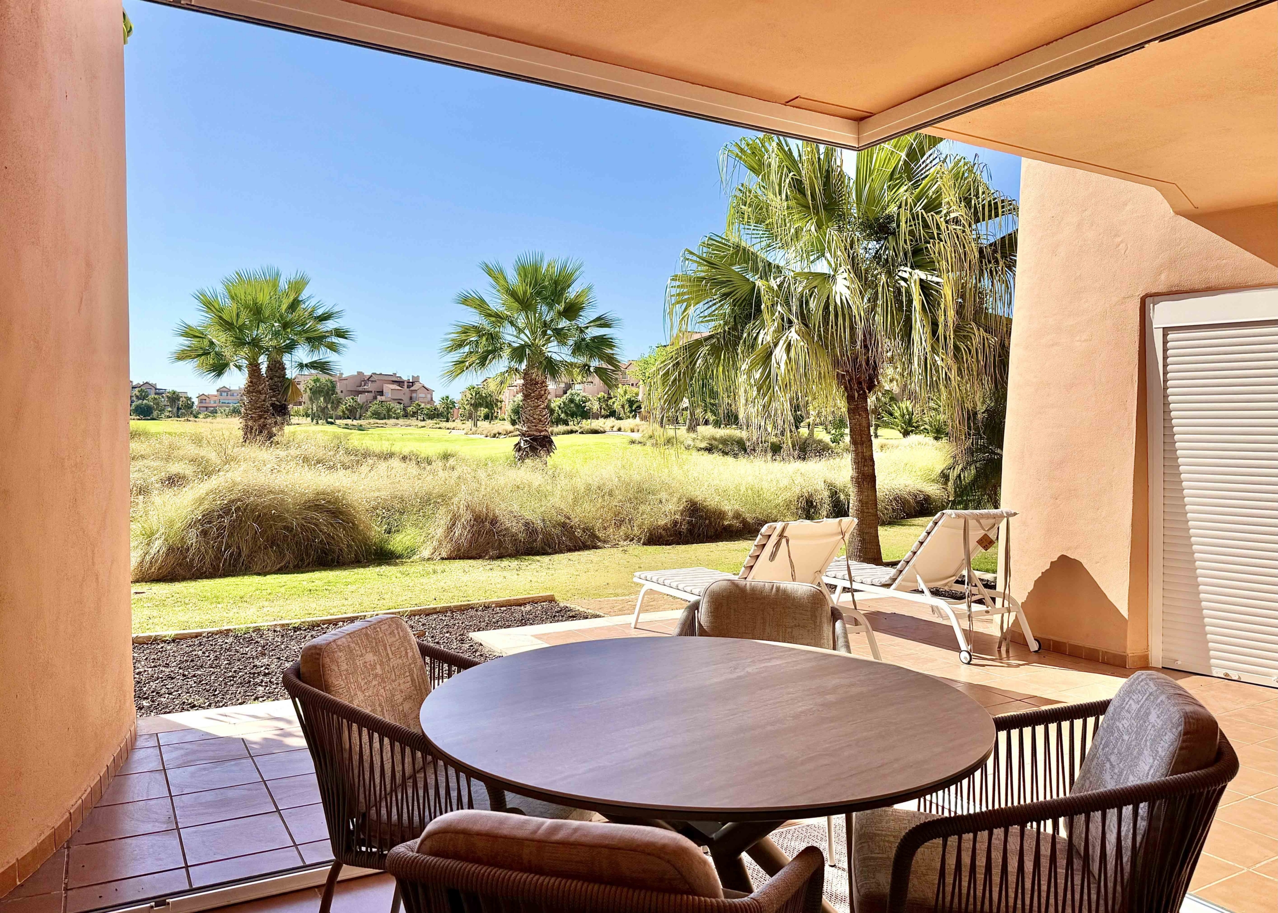 Enclosed terrace with glass curtains overlooking the golf course and lake at Mar Menor Golf Resort, exclusively marketed by Levante Properties.