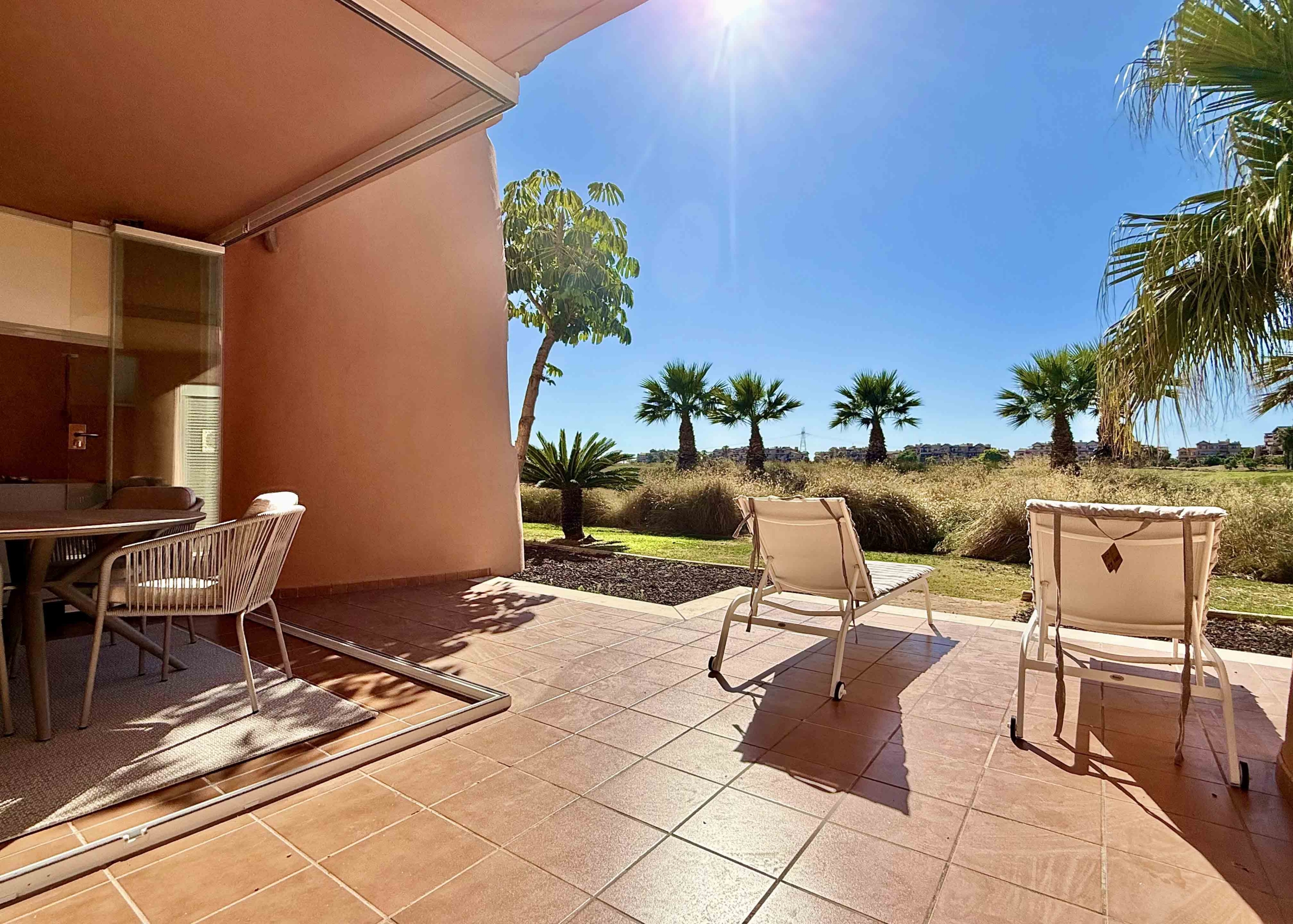 Private west-facing terrace with sun loungers at an upgraded one-bedroom apartment on Mar Menor Golf Resort, exclusively marketed by Levante Properties.