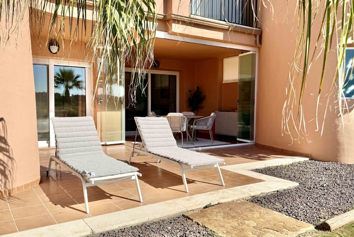Private west-facing terrace with sun loungers at an upgraded one-bedroom apartment on Mar Menor Golf Resort, exclusively marketed by Levante Properties.