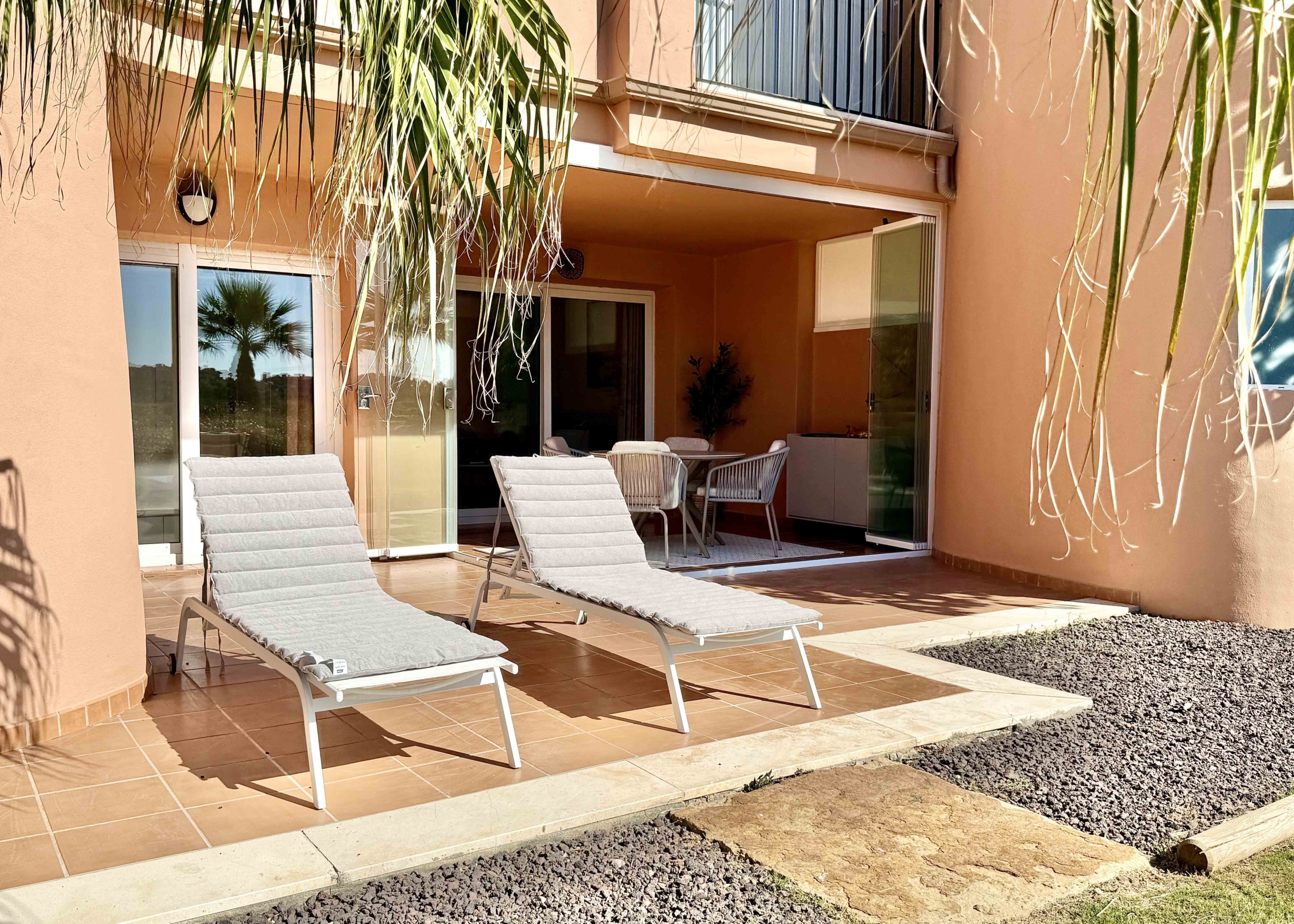 Private west-facing terrace with sun loungers at an upgraded one-bedroom apartment on Mar Menor Golf Resort, exclusively marketed by Levante Properties.