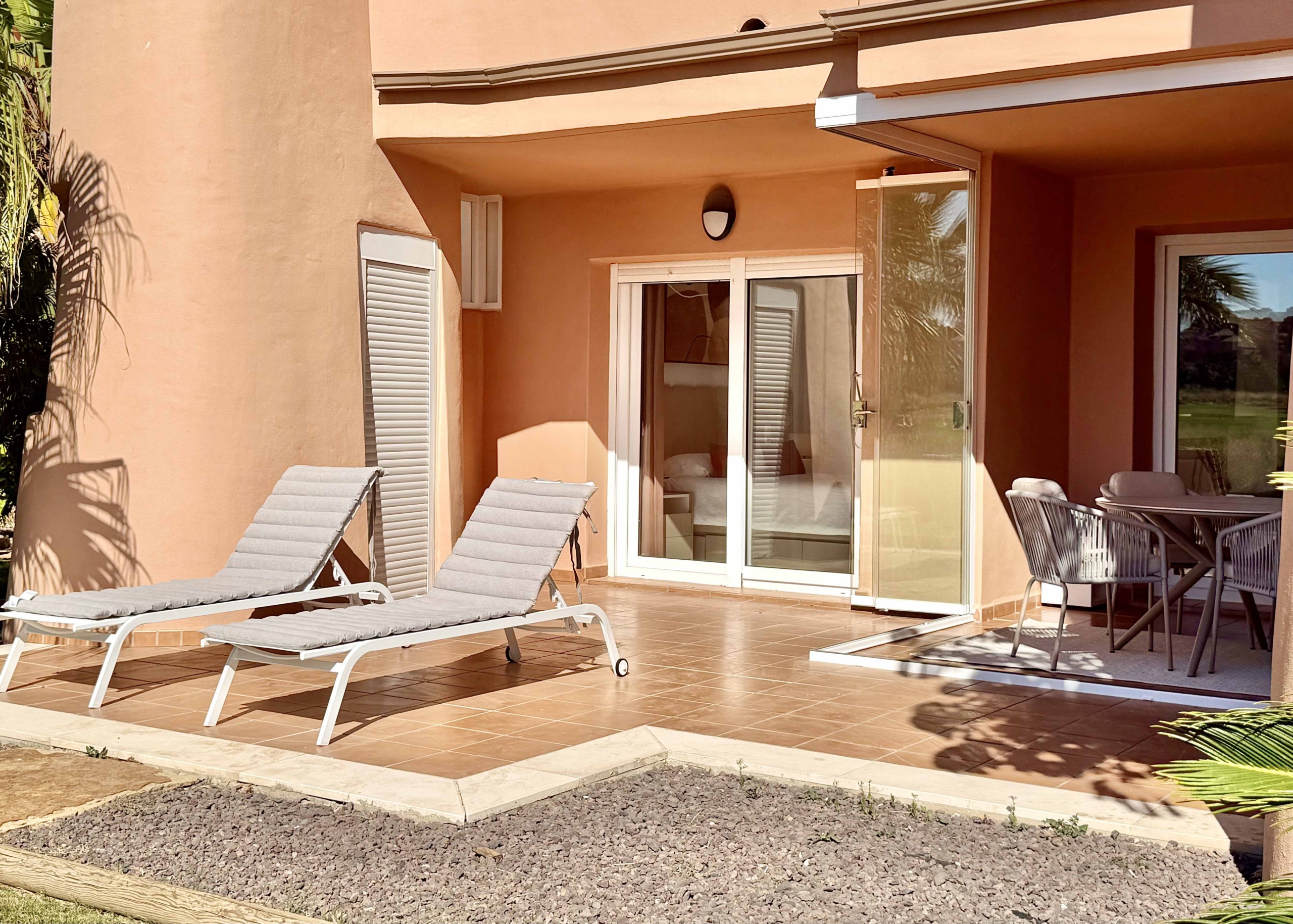 Private west-facing terrace with sun loungers at an upgraded one-bedroom apartment on Mar Menor Golf Resort, exclusively marketed by Levante Properties.