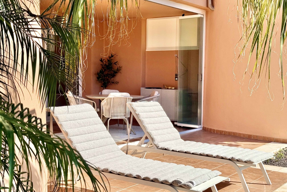 Private west-facing terrace with sun loungers at an upgraded one-bedroom apartment on Mar Menor Golf Resort, exclusively marketed by Levante Properties.
