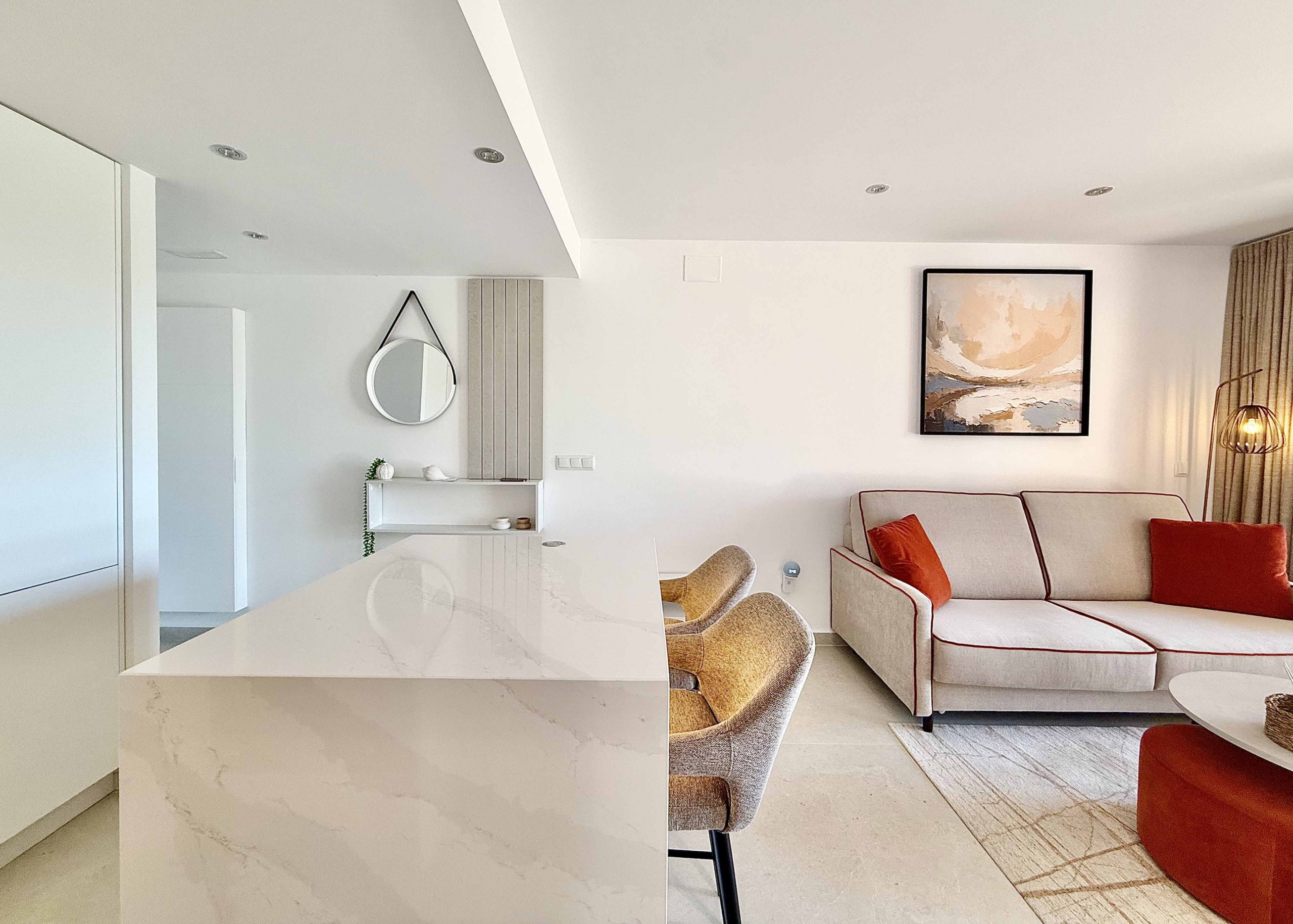 Modern white kitchen with breakfast island in an upgraded one-bedroom apartment for sale on Mar Menor Golf Resort by Levante Properties.