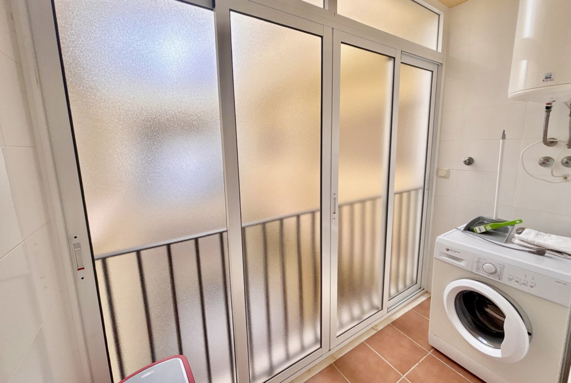 Utility area with washing machine and frosted sliding doors in a Boulevard apartment on Mar Menor Golf Resort