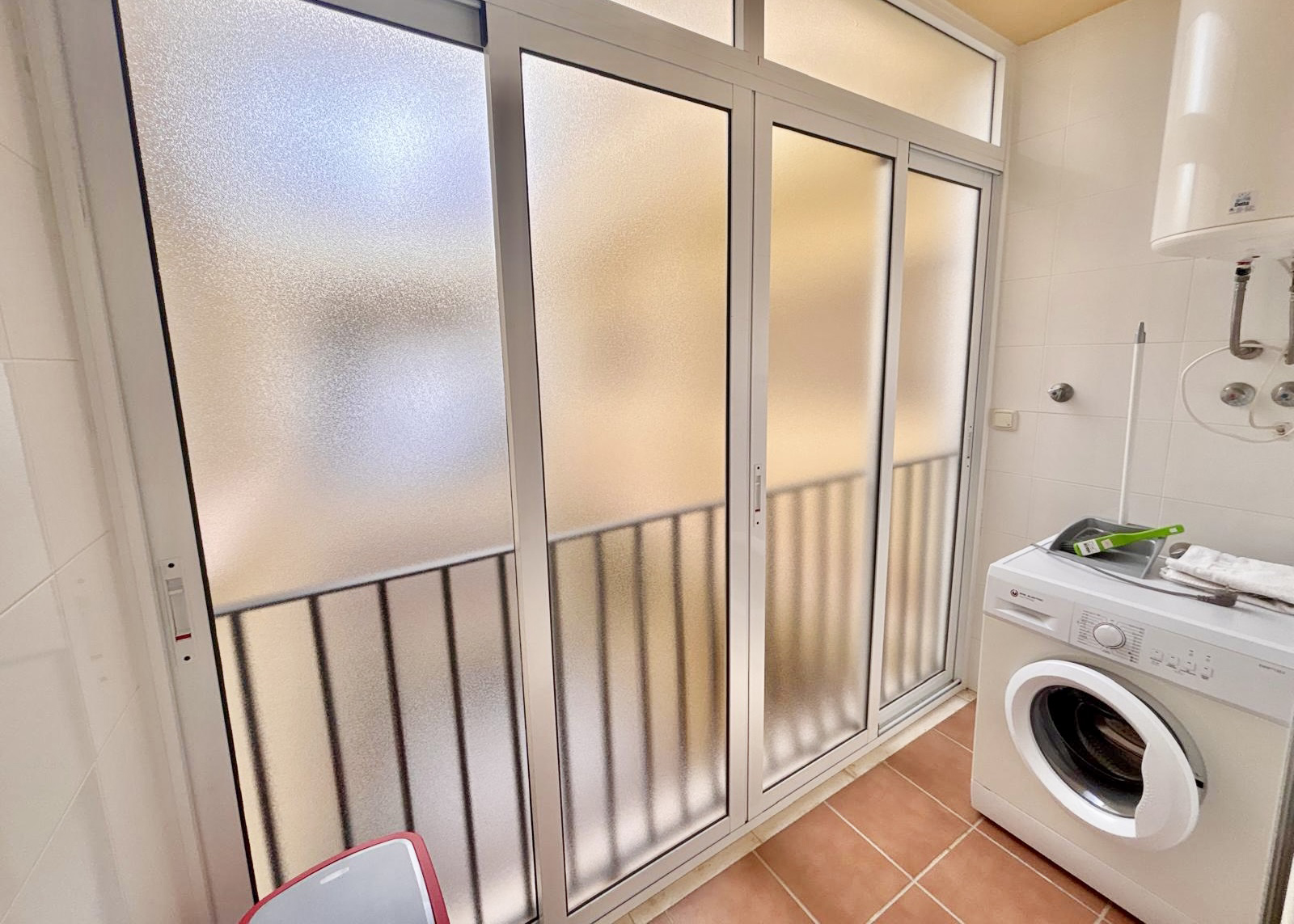 Utility area with washing machine and frosted sliding doors in a Boulevard apartment on Mar Menor Golf Resort
